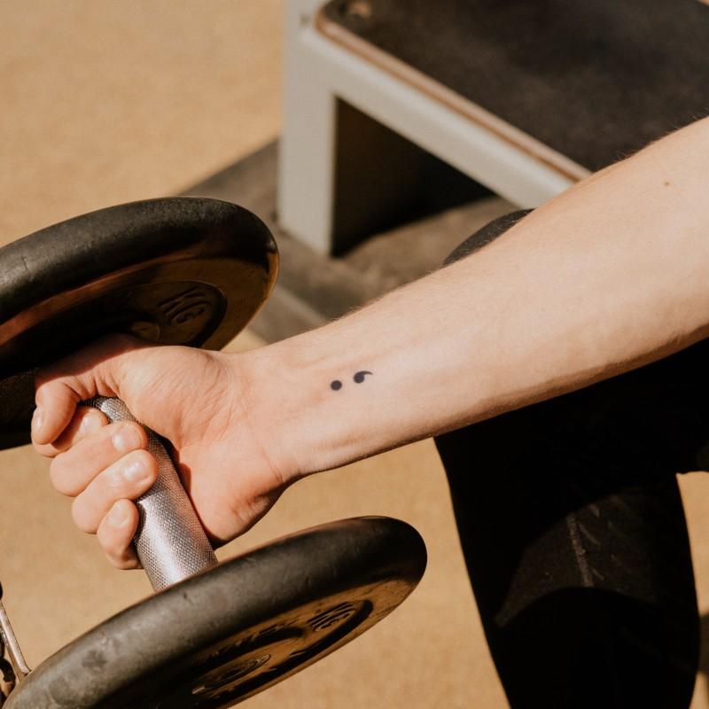 BMC road bicycle on a mountain placed on a barbell tattoo idea | TattoosAI